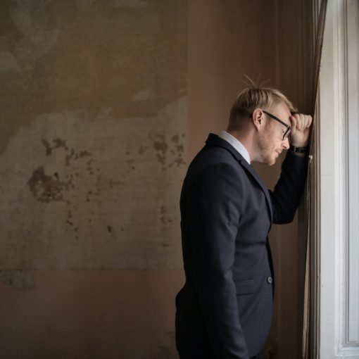 desperate evicted male entrepreneur standing near window