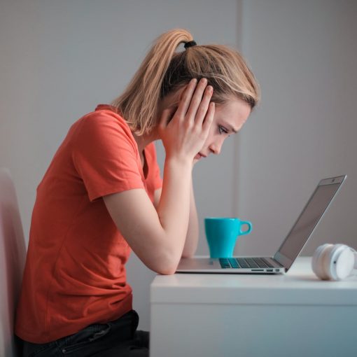 young troubled woman using laptop at home