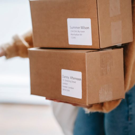 crop unrecognizable woman carrying boxes and entering post office