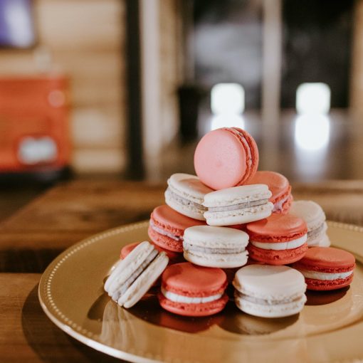 sweet macaroons on round plate on wooden table