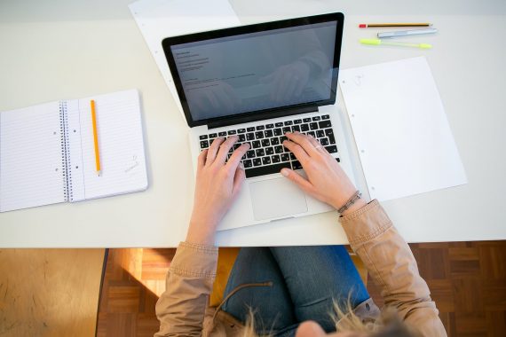 woman working on laptop with documents