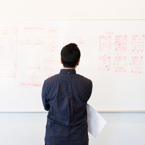 man standing infront of white board