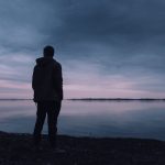 person standing near lake