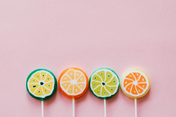 assorted colorful lollipops on pink background