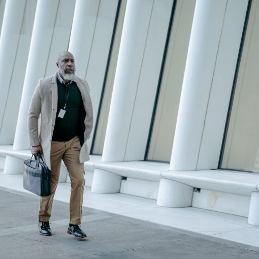man in corporate attire holding a black handbag