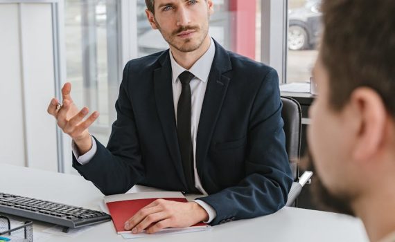 man sitting at desk in office consulting client