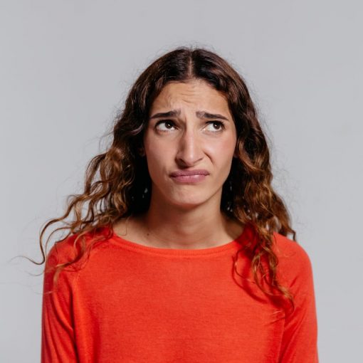 woman in red crew neck shirt making facial expression