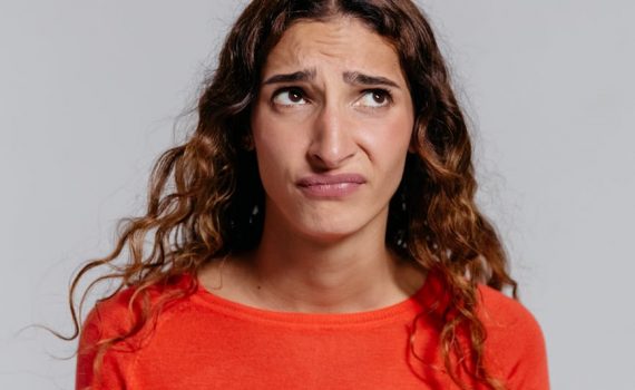 woman in red crew neck shirt making facial expression