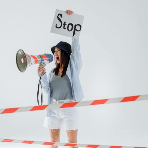 person holding megaphone while holding a placard