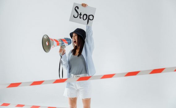 person holding megaphone while holding a placard