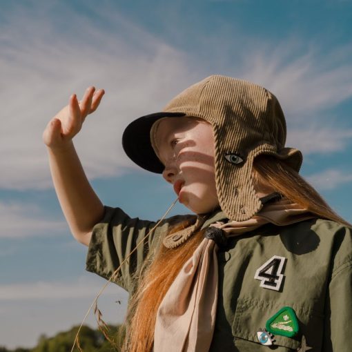 girl scout standing outside and blocking the sun from her face with her hand